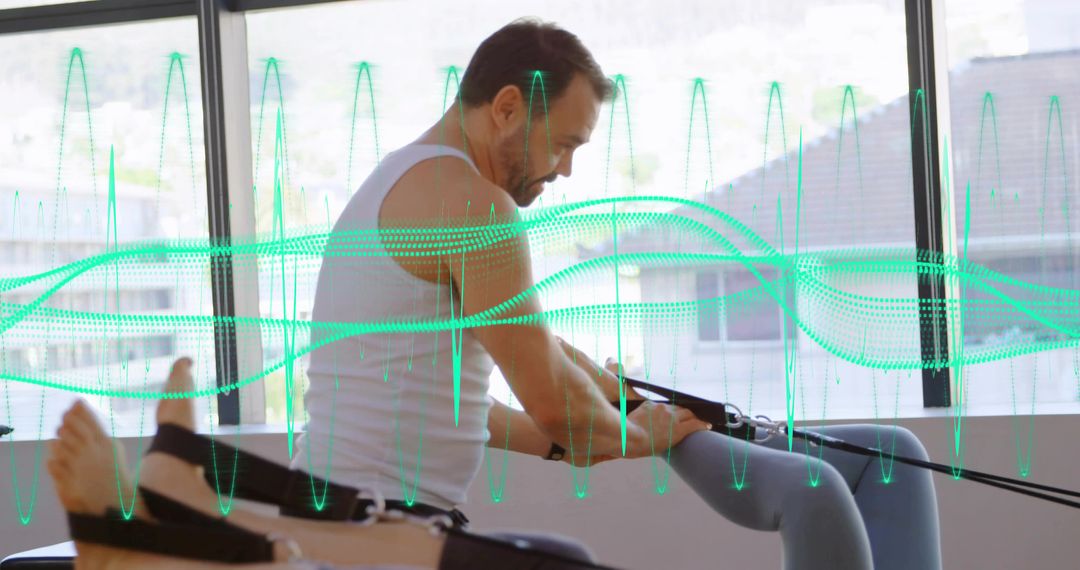 Senior man building strength on Pilates reformer using resistance straps in bright studio
