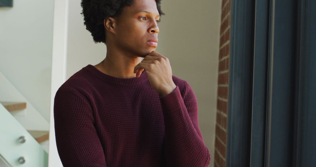 Pensive African American Man by Window in Natural Light