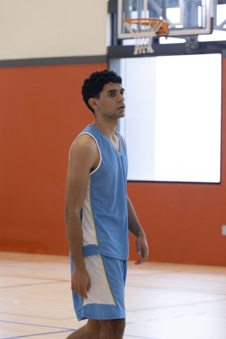 Focused Basketball Player Intently Perusing Game on Indoor Court