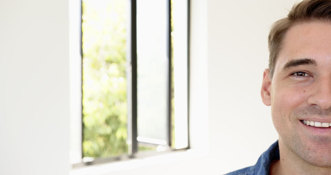 Man Relaxing by Window with Greenery and Natural Light in Bright Room