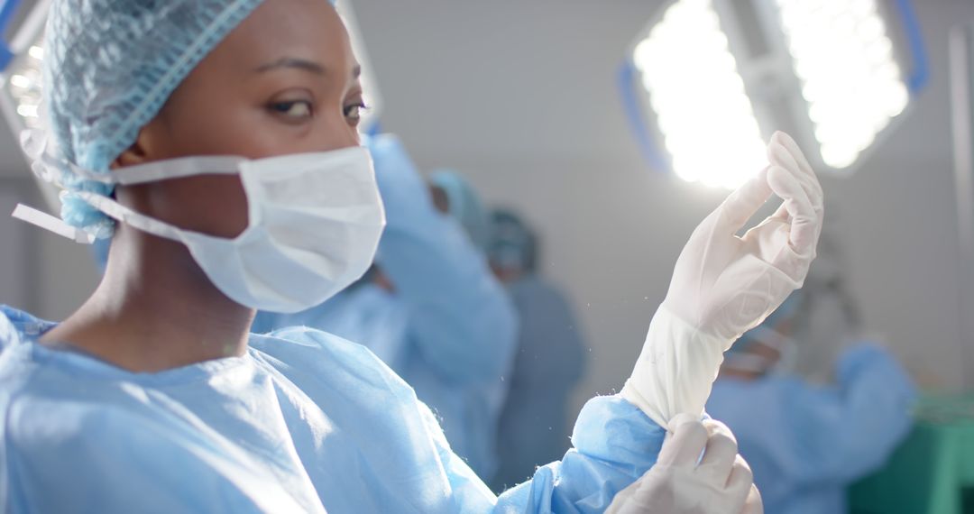 Focused Surgeon Putting On Gloves In Operating Room - Free Images, Stock Photos and Pictures on Pikwizard.com