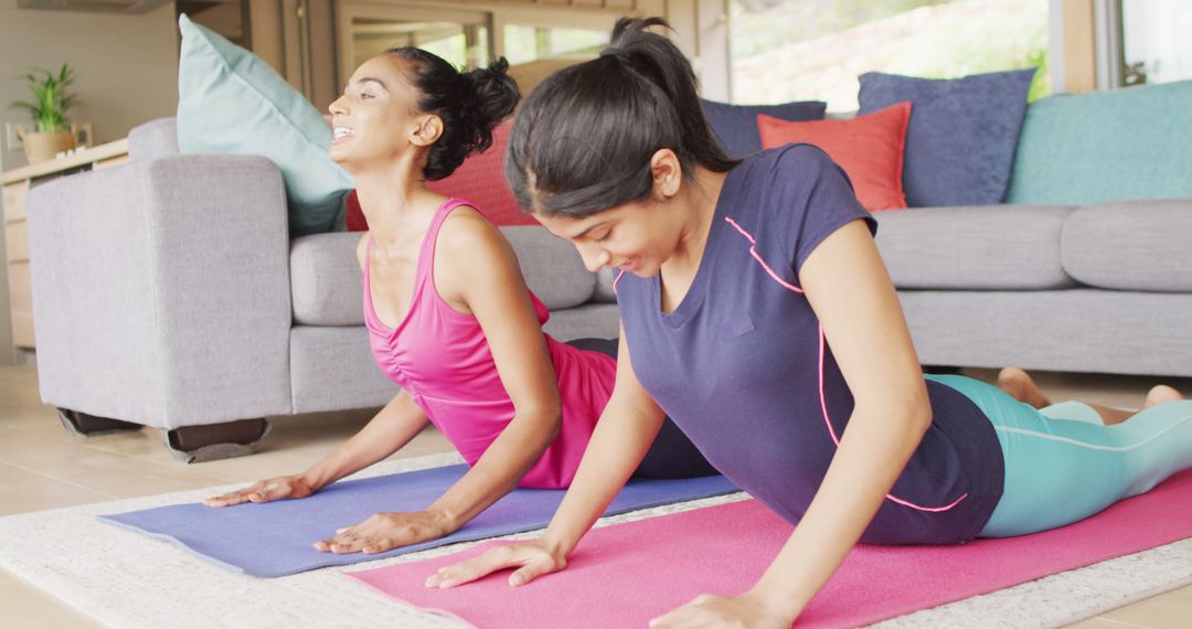 Image of relaxed diverse women practicing yoga on mat at home - Free Images, Stock Photos and Pictures on Pikwizard.com