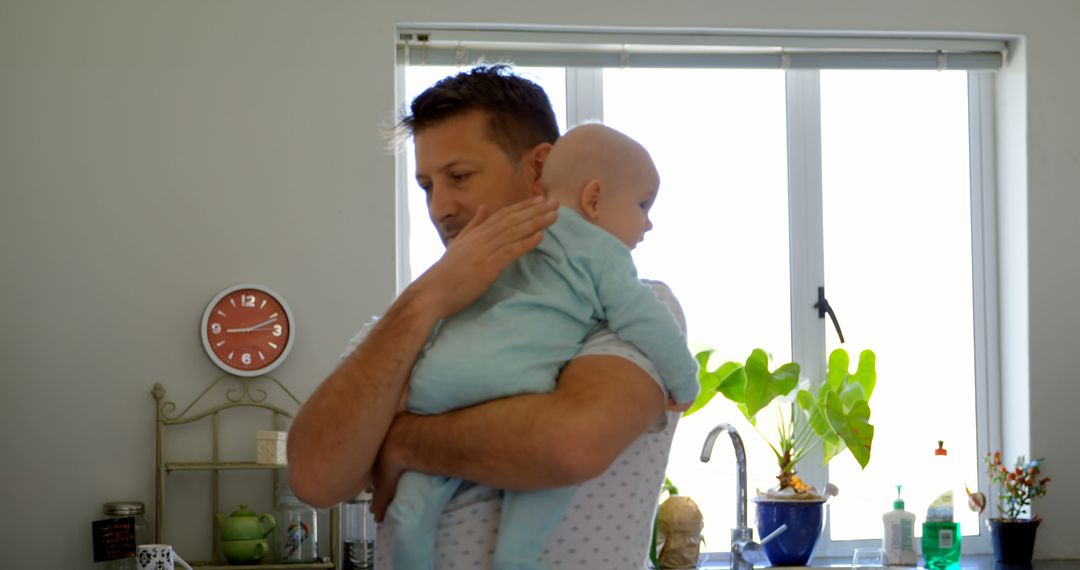 Father Comforting Baby in Bright Modern Kitchen - Free Images, Stock Photos and Pictures on Pikwizard.com