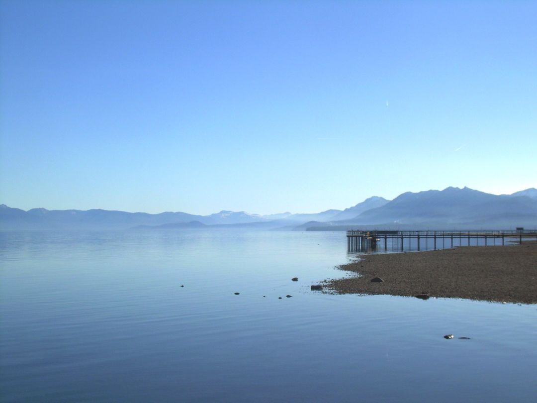 Peaceful Lakeshore with Pier and Mountain Range - Free Images, Stock Photos and Pictures on Pikwizard.com