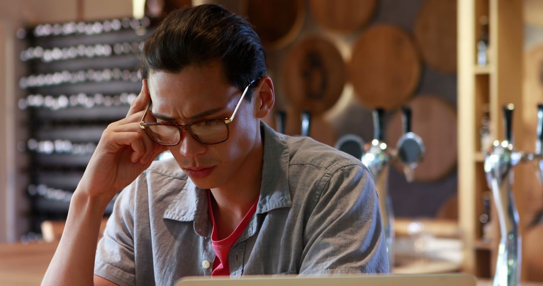 Young Asian Man Deeply Focused While Working on Laptop with Copy Space