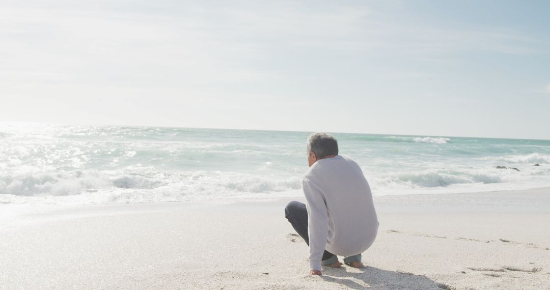 Senior Man Reflecting by Seaside at Sunset