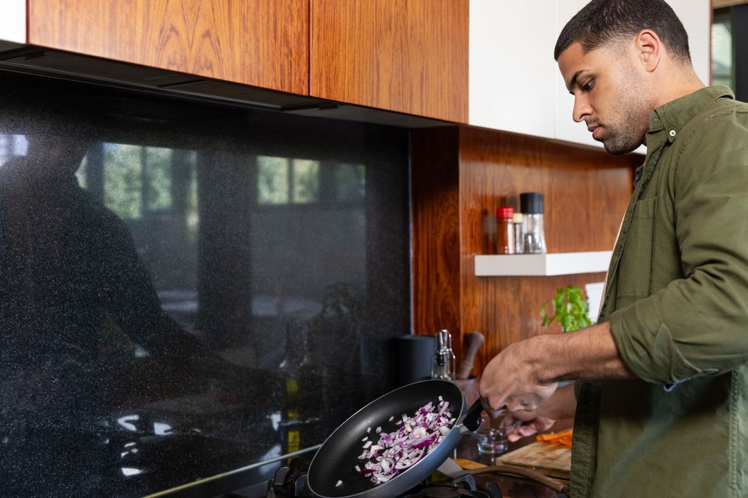 Man Cooking Onions in Modern Home Kitchen