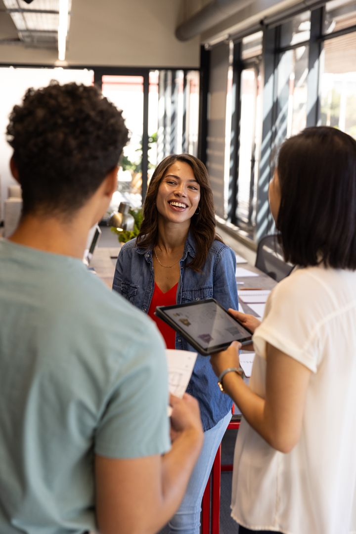 Diverse Colleagues in Open-Plan Office Engaged in Productive Discussion