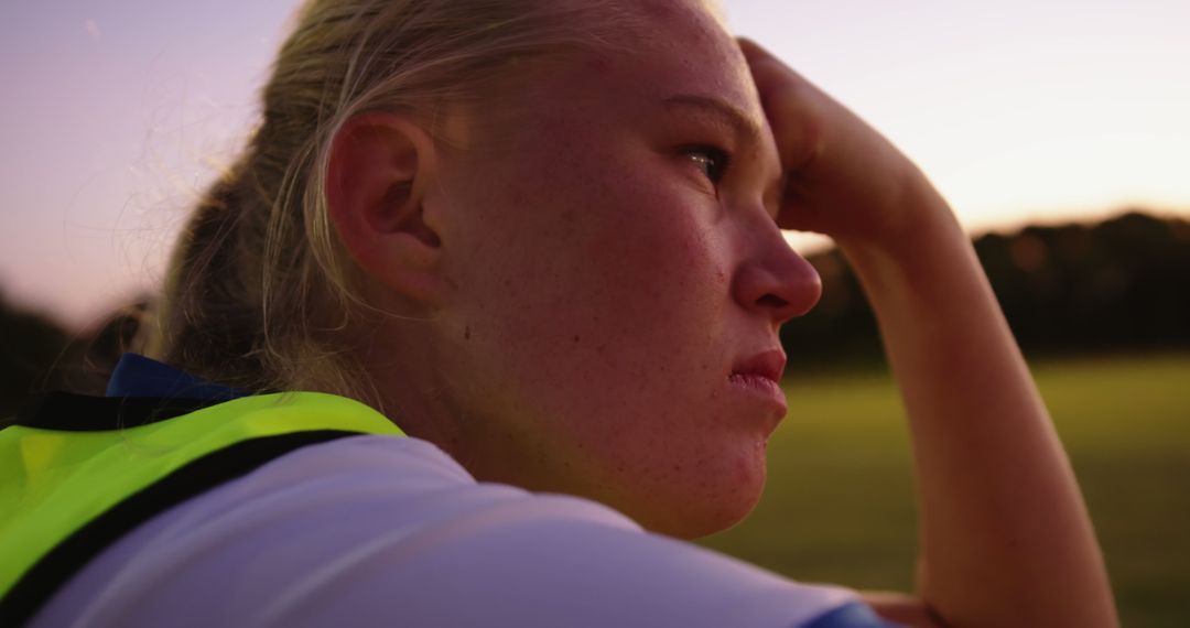 Determined Female Soccer Player Reflecting After Training at Sunset - Free Images, Stock Photos and Pictures on Pikwizard.com