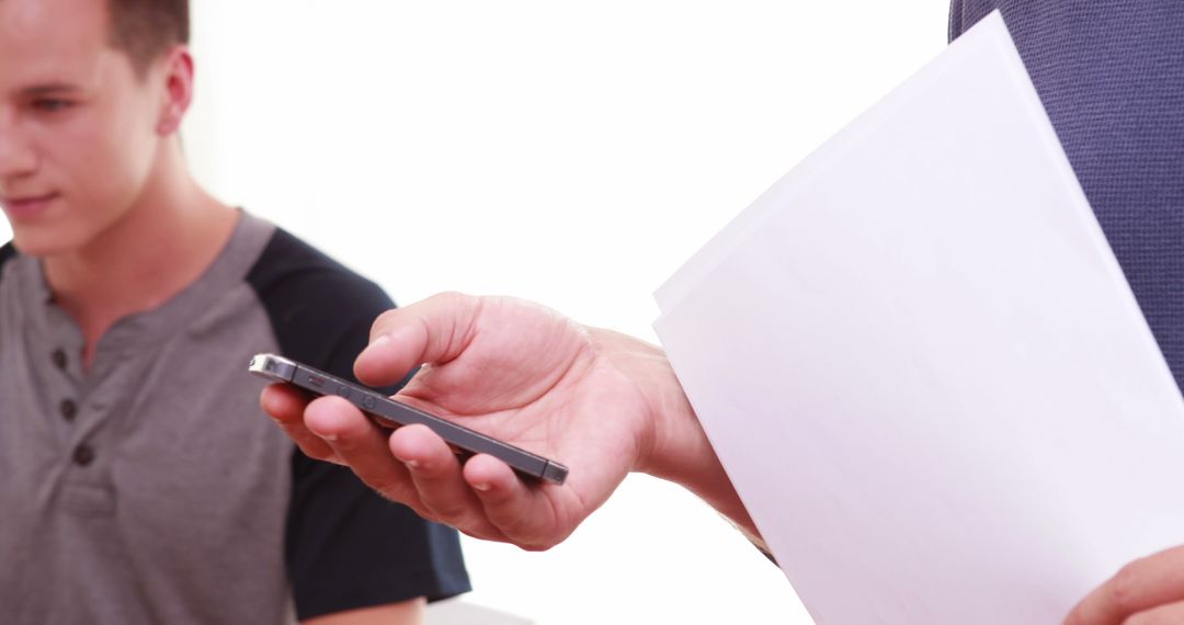 Closeup of Man Holding Smartphone in Office Meeting - Free Images, Stock Photos and Pictures on Pikwizard.com