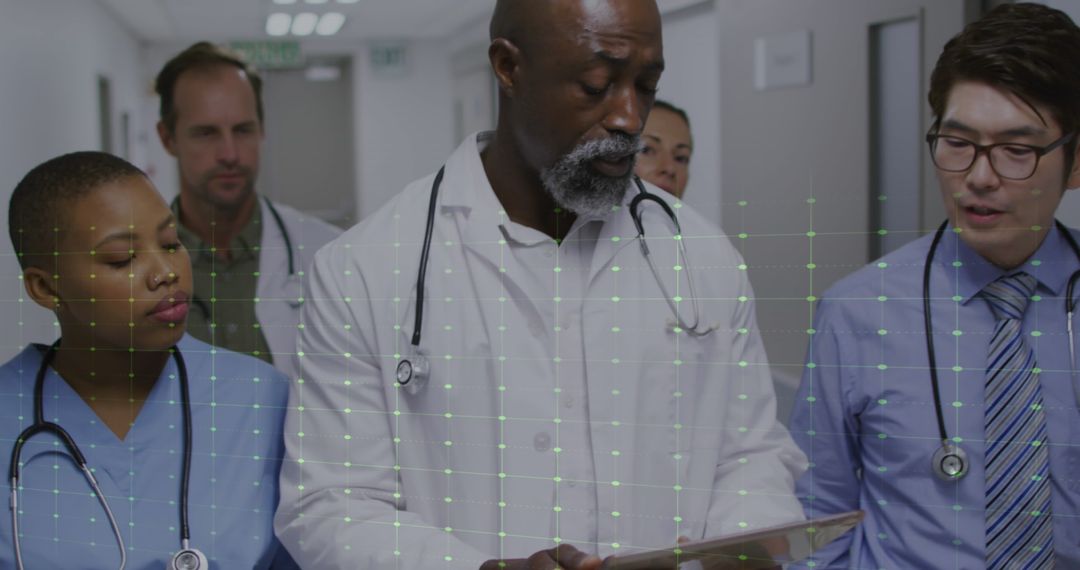 Diverse Medical Team Reviewing Digital Data in Hospital Corridor