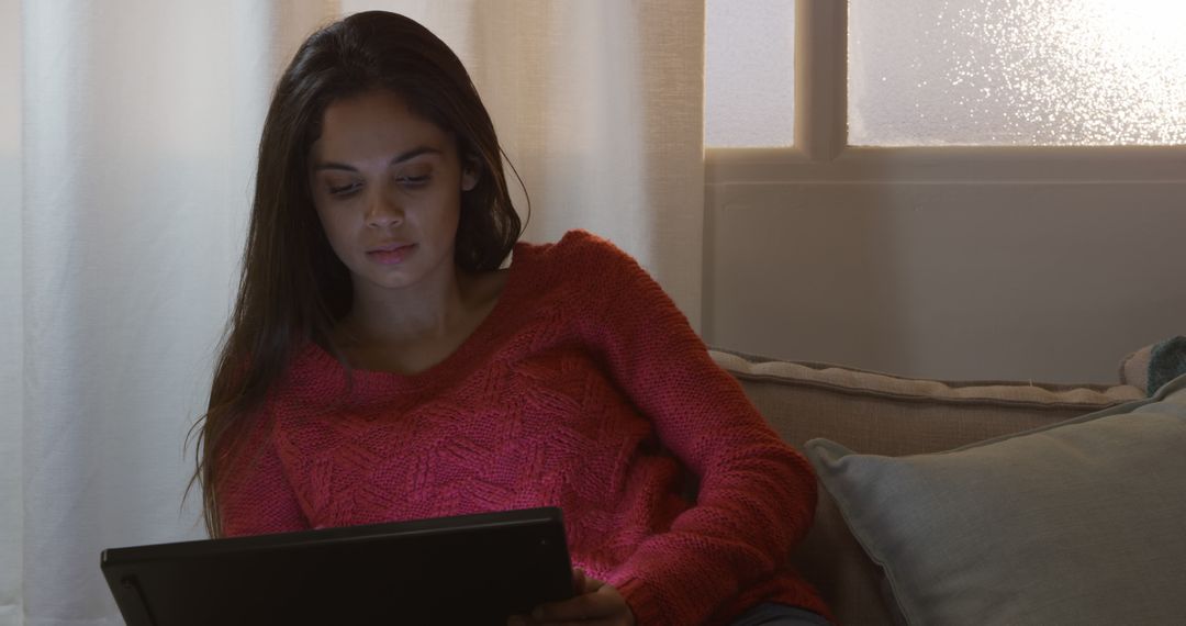 Woman Using Tablet for Relaxation in Dimly Lit Room - Free Images, Stock Photos and Pictures on Pikwizard.com