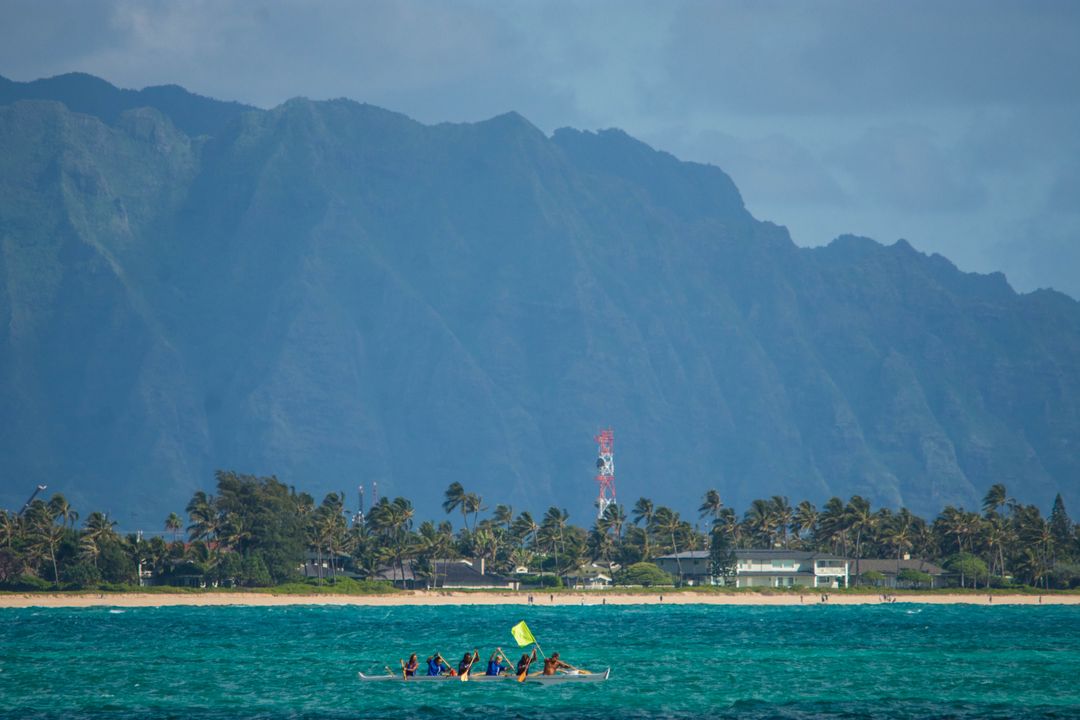 Team Paddling Canoe in Tropical Ocean with Mountainous Backdrop - Free Images, Stock Photos and Pictures on Pikwizard.com