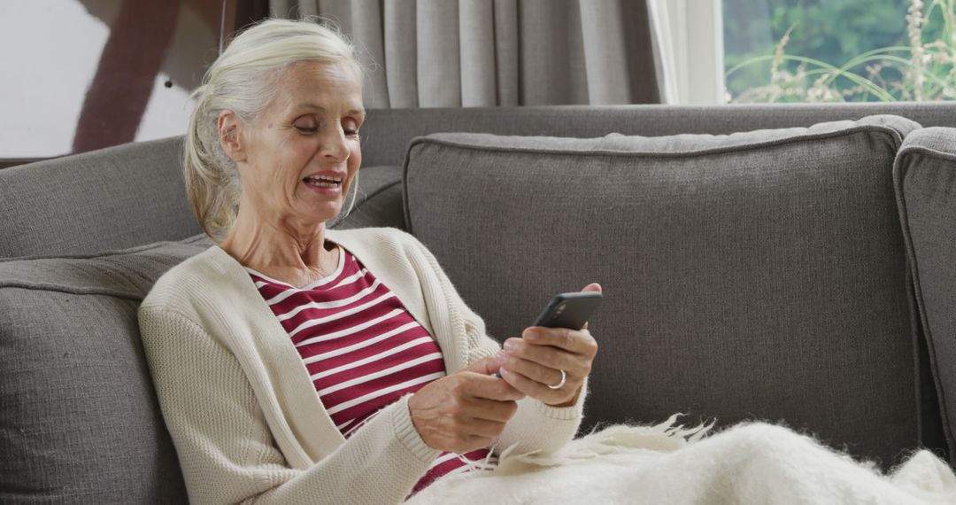 Senior Woman Relaxing on Couch Using Smartphone at Home - Free Images, Stock Photos and Pictures on Pikwizard.com