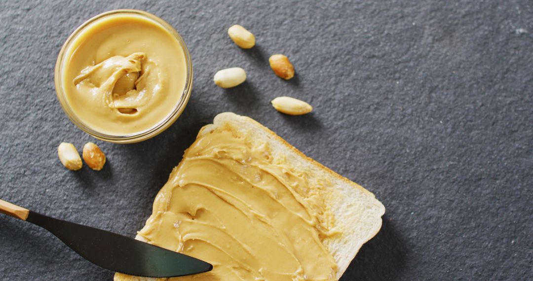 Toast with Creamy Peanut Butter on Dark Surface
