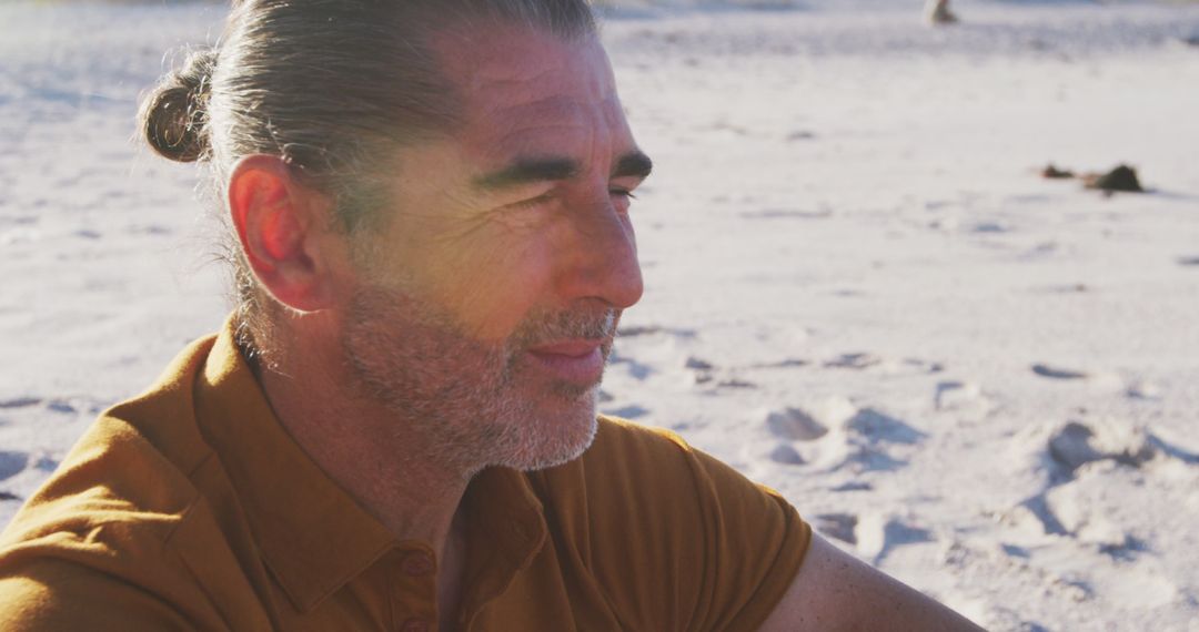 Serene Mature Man Reflecting on Sandy Beach at Sunset - Free Images, Stock Photos and Pictures on Pikwizard.com