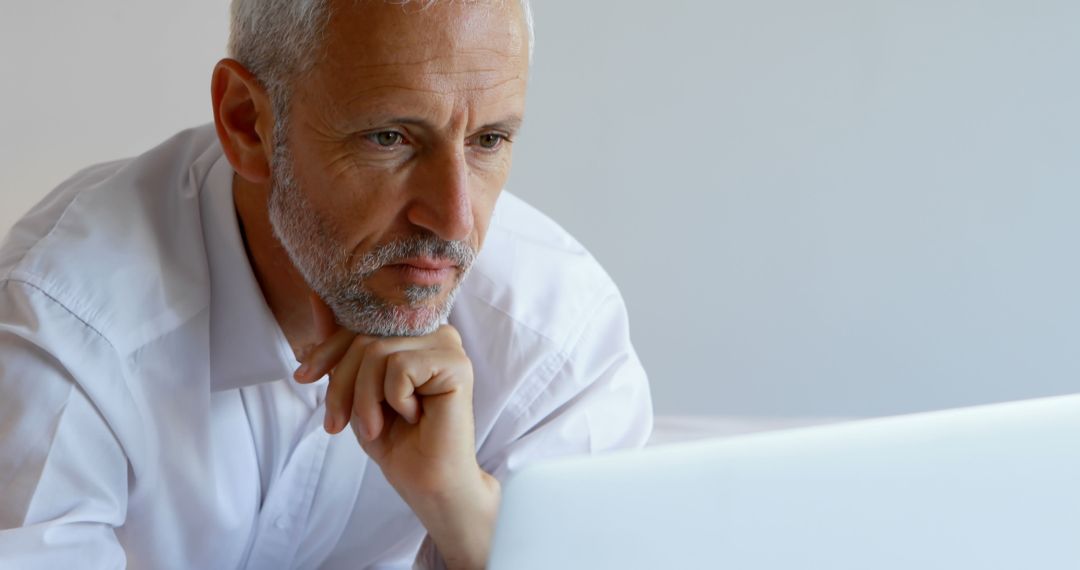 Mature Businessman Focused on Laptop Screen in Office - Free Images, Stock Photos and Pictures on Pikwizard.com