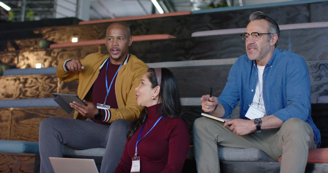 Diverse coworkers collaborating at conference, brainstorming with laptop and tablet