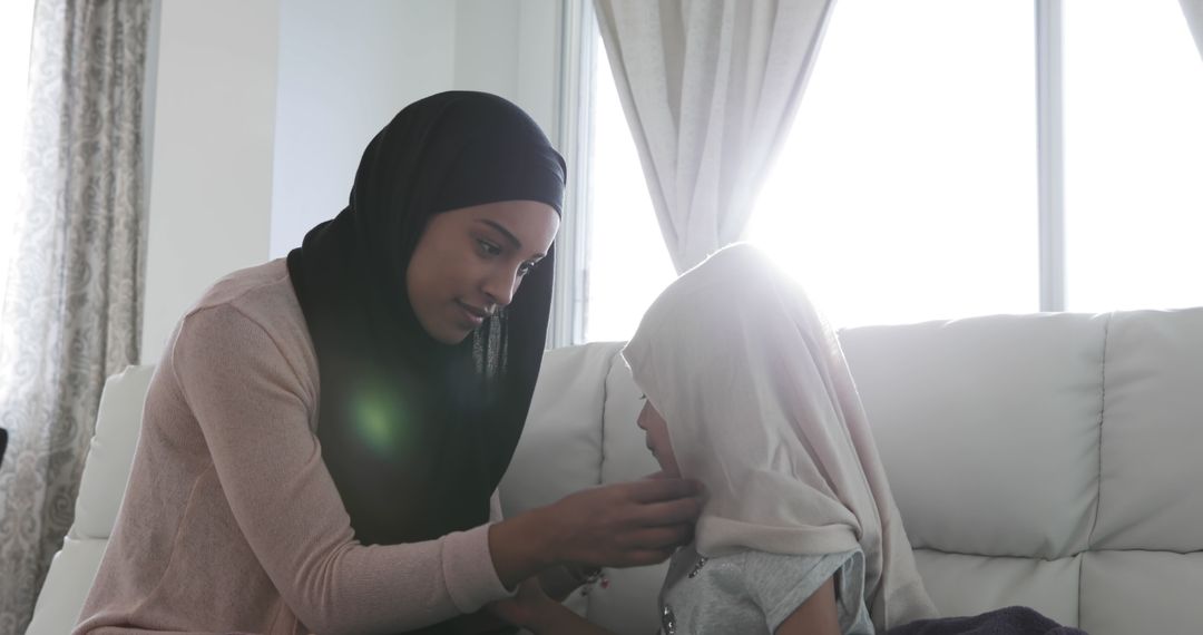 Mother Adjusting Daughter's Hijab at Home