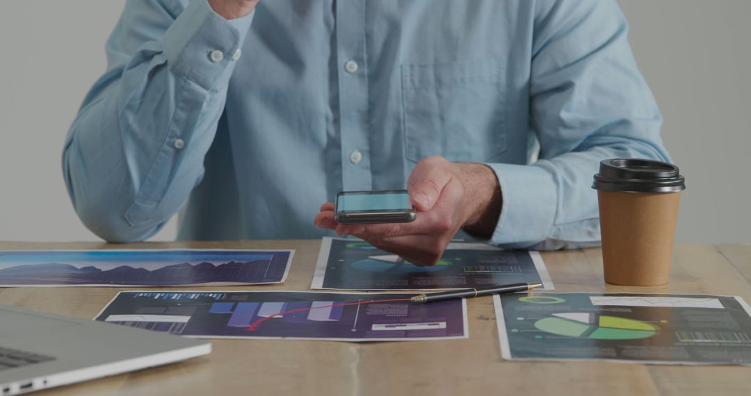 Businessman Analyzing Graphs and Data Reports with Smartphone