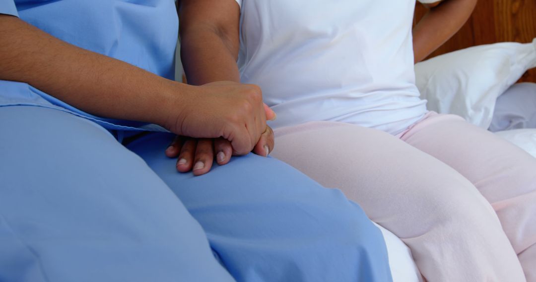 Front view of female doctor holding senior woman hand on bed in a comfortable home - Free Images, Stock Photos and Pictures on Pikwizard.com