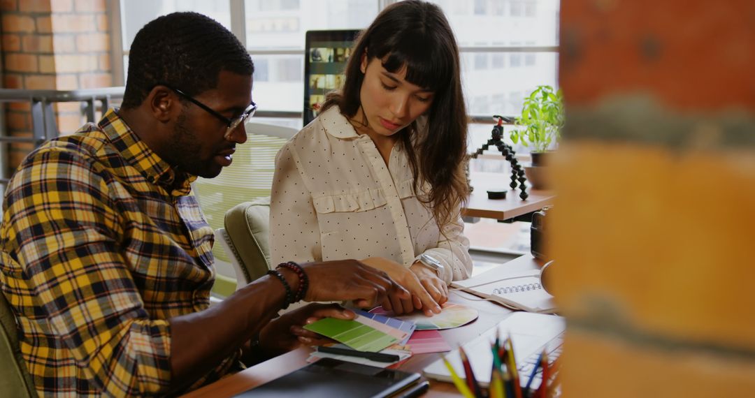 Creative Designers Collaborating on Color Scheme in Modern Office