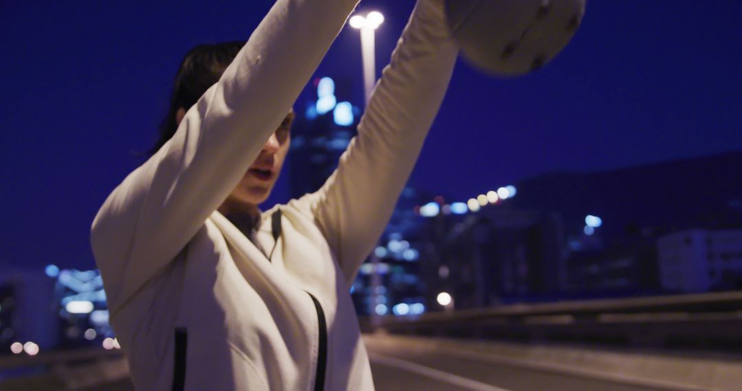 Woman Lifting Helmet in Evening Cityscape with Lights - Free Images, Stock Photos and Pictures on Pikwizard.com