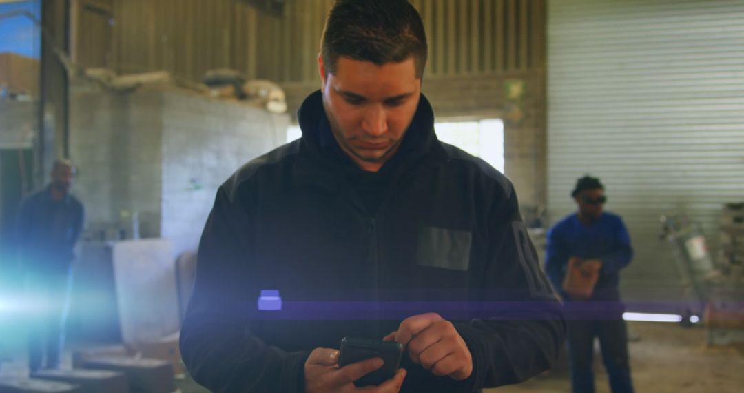 Focused Factory Worker Using Smartphone in Industrial Setting
