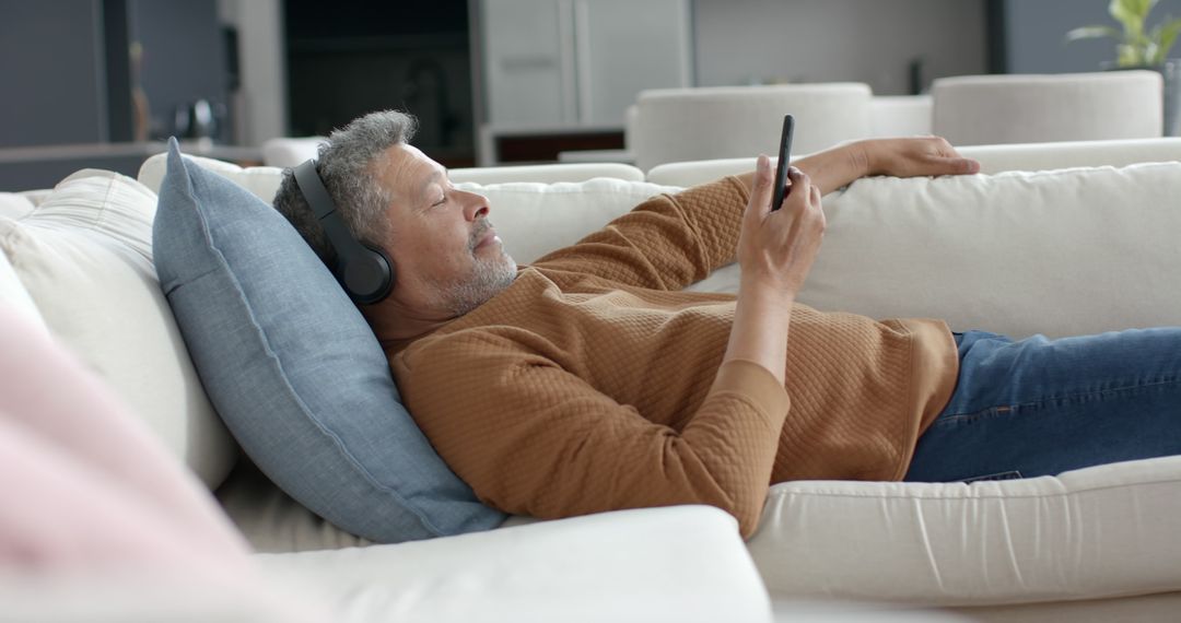 Relaxed Senior Man Listening to Music on Smartphone at Home - Free Images, Stock Photos and Pictures on Pikwizard.com