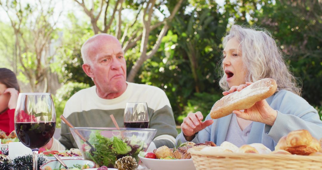 Elderly Couple Having Outdoor Picnic Discussing Bread Roll - Free Images, Stock Photos and Pictures on Pikwizard.com