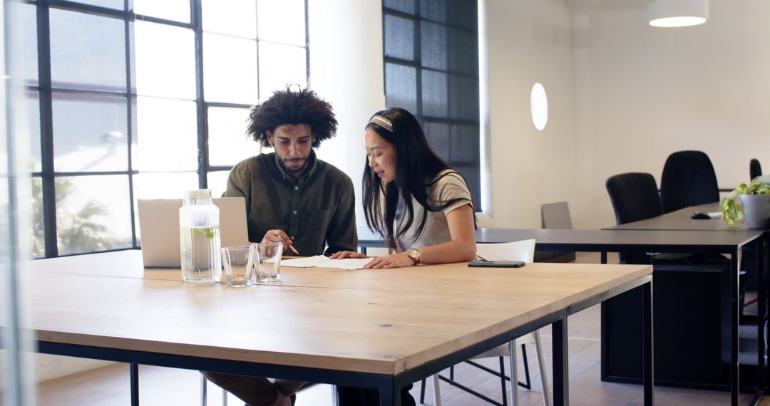 Diverse Colleagues Discussing Documents in Bright Modern Office