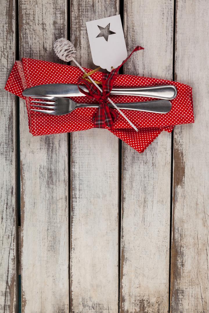 Festive Cutlery with Red Napkin on Rustic Wooden Table - Free Images, Stock Photos and Pictures on Pikwizard.com