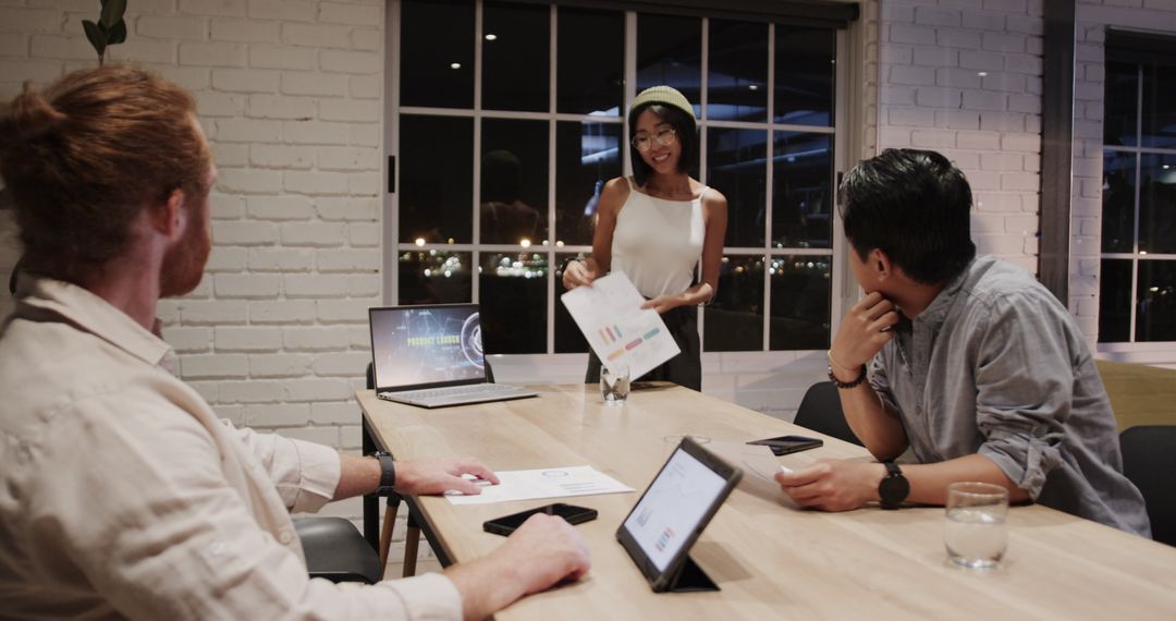 Nighime Office Meeting with Laptop and Tablets for Innovation Discussion