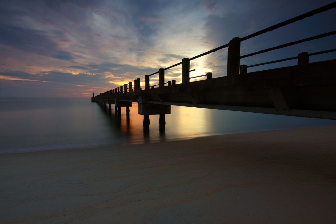 Serene Sunset Over Tranquil Ocean with Wooden Pier - Free Images, Stock Photos and Pictures on Pikwizard.com