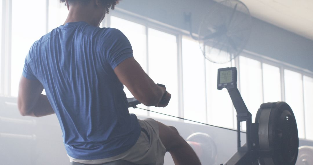 Man Using Rowing Machine for Intense Fitness Training