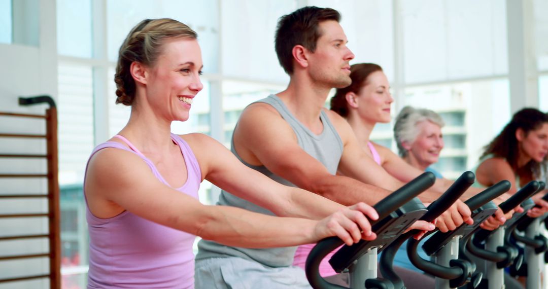 Group of People Smiling While Exercising on Stationary Bikes - Free Images, Stock Photos and Pictures on Pikwizard.com