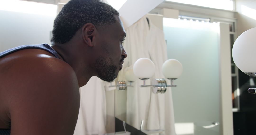 Man Analyzing Reflection in Bathroom Mirror for Personal Grooming