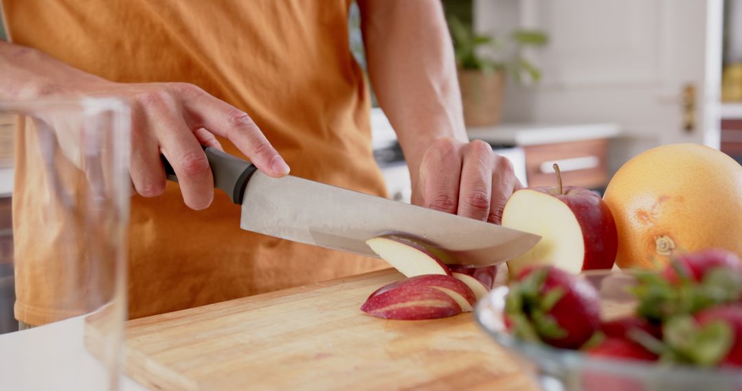 Person Preparing Fresh Fruit for Healthy Smoothie in Modern Kitchen