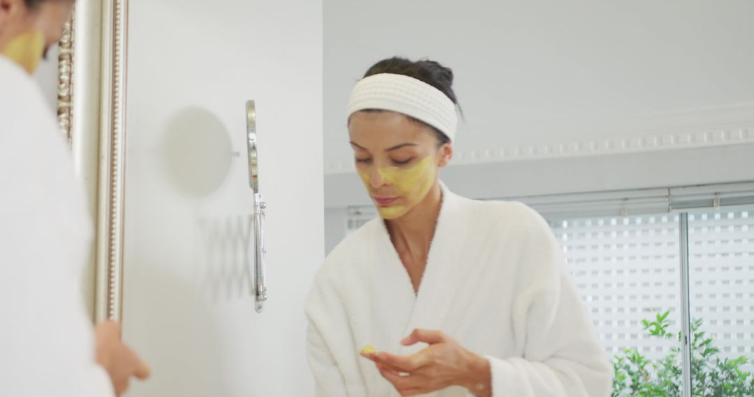 Woman Applying Face Mask in Bathroom Getting Ready for Spa Day - Free Images, Stock Photos and Pictures on Pikwizard.com