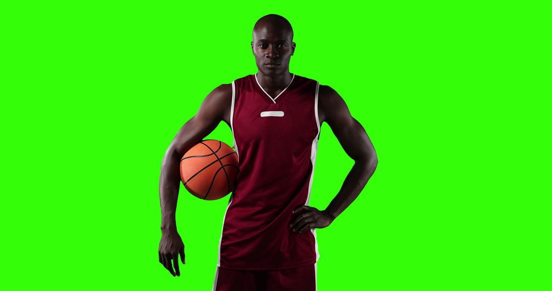 Basketball Player in Maroon Uniform Holding Ball on Green Background - Free Images, Stock Photos and Pictures on Pikwizard.com