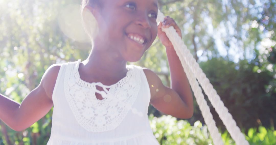 Joyful African American Child Swinging in Sunlit Park - Free Images, Stock Photos and Pictures on Pikwizard.com