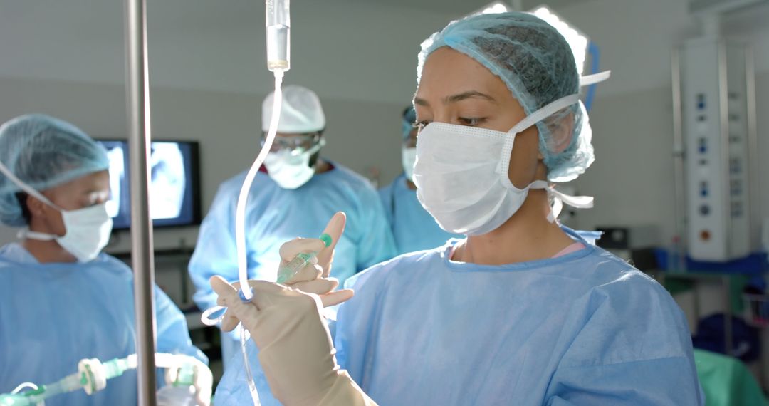 Female surgeon preparing IV during surgery in operating room - Free Images, Stock Photos and Pictures on Pikwizard.com