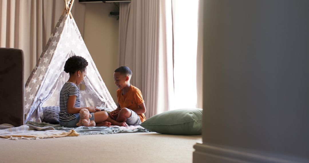 Siblings Enjoying Playtime in Cozy Indoor Teepee Tent