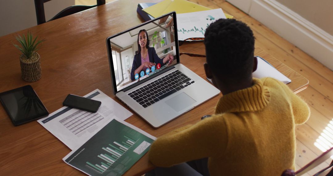 Man Engaging in Virtual Meeting with Colleague on Laptop