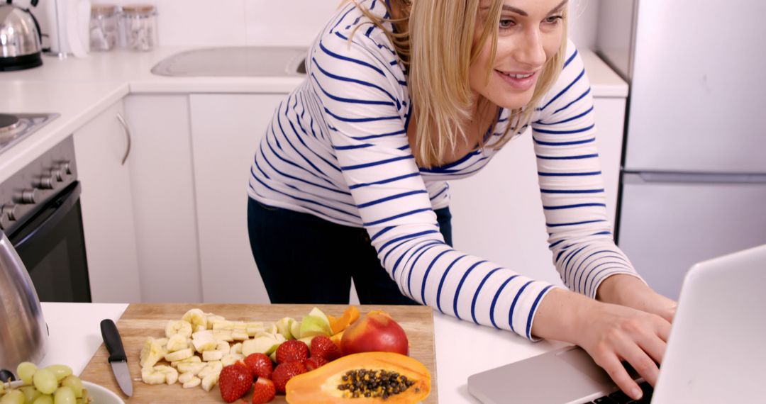 Woman Preparing to Eat Healthy While Using Laptop in Kitchen - Free Images, Stock Photos and Pictures on Pikwizard.com