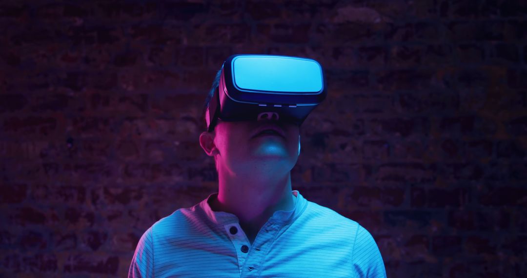 Man Immersed in Virtual Reality with VR Headset in Neon Lighting - Free Images, Stock Photos and Pictures on Pikwizard.com