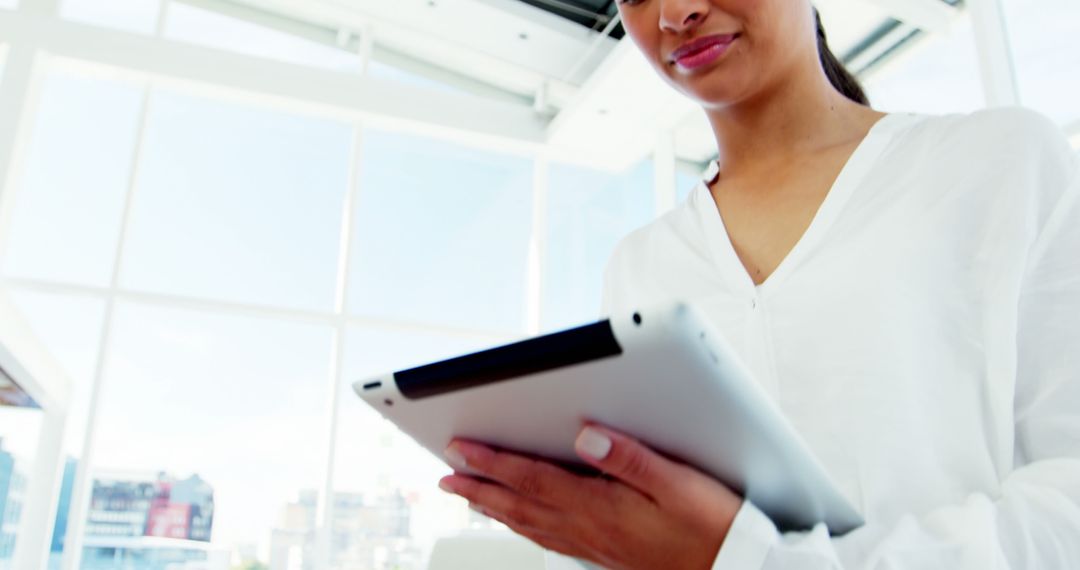 Woman Using Digital Tablet in Bright Office - Free Images, Stock Photos and Pictures on Pikwizard.com