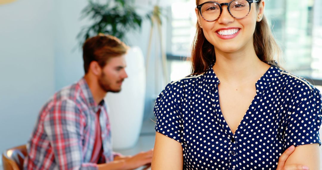 Smiling Woman with Glasses in Office with Colleague Working - Free Images, Stock Photos and Pictures on Pikwizard.com