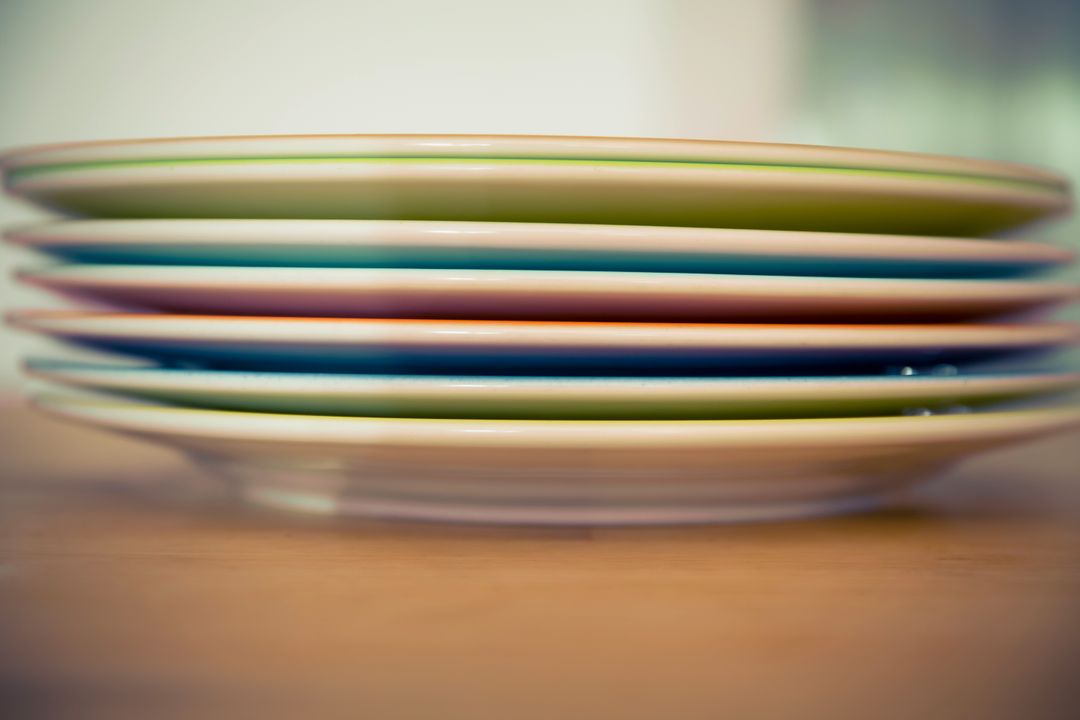 Stacked Colorful Plates on Wooden Table - Free Images, Stock Photos and Pictures on Pikwizard.com