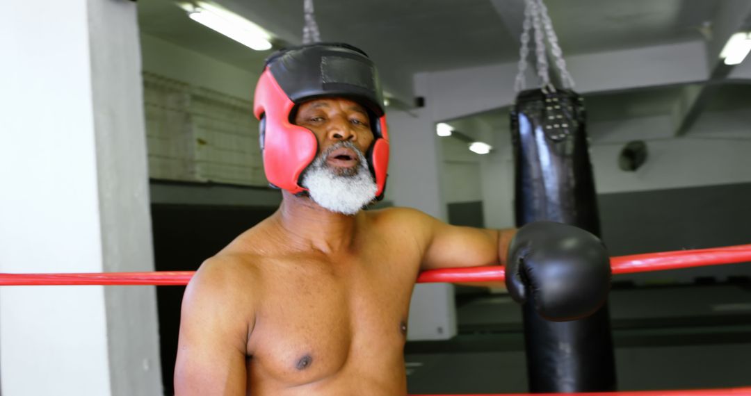 Senior Boxer Relaxing in Gym with Protective Headgear - Free Images, Stock Photos and Pictures on Pikwizard.com